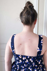 Coudre un empiècement en smocks dans le dos de la robe personnalisée avec le patron de couture Bustier à smocks par Atelier Charlotte Auzou. Le tissu est une popeline de viscose marine à fleurs Petali par Eglantine et Zoé. 
